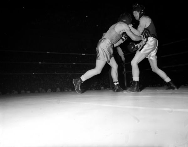 University of Wisconsin boxer Steve Gremban, right, wards off two-fisted blows by University of Idaho boxer Frank Eschevarria.