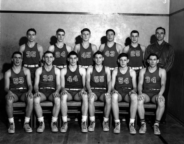 Group portrait of eleven uniformed players of the Wisconsin High School boy's basketball team with their coach.