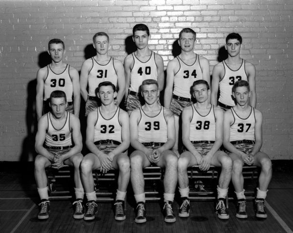 Group portrait of 12 basketball players in uniform.