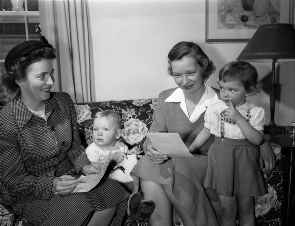 As part of a League of a Women Voters house to house canvas to encourage voting, Mrs. Horace (Marion) Wilkie (left), chair of the Westmorland Unit, is shown with Mrs. David (Janice) Reynolds and her two children, Dick, 20 months and Phoebe, 3 years.
