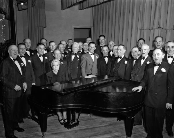 Members of the Madison Maennerchor, the oldest singing society in Wisconsin, standing around their accompanist, Mrs. Grace L. Snell, at the group's ninety-eighth birthday party at the Turner Hall.