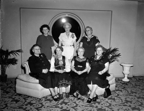 Charter members of the Fremsyn Lodge No. 53 of the Daughters of Norway pose for a group portrait at the Edgewater Hotel during the Thirty-Fifth Anniversary Banquet. Seated, left to right, are: Mrs. O.T. (Ingeborg), Mrs. Dagney Quisling, Mrs. Adolph (Alvilde) Benson, and Mrs. Henry (Elisa) Odegaard. Standing (left to right) are: Mrs. Peter (Thea) Kalbacken, Mrs. Sverre Solberg, and Mrs. Even (Janetha) Hansen.
