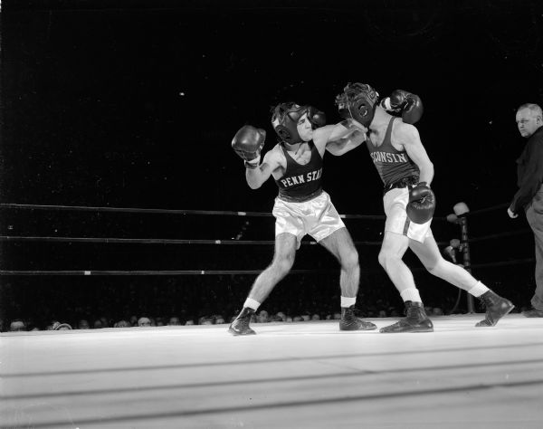 James "Red" Sreenan, Wisconsin 130-pounder, lands a right punch to the ear of Penn State's Harry Papacharalambous during their bout, which was fought to a draw.