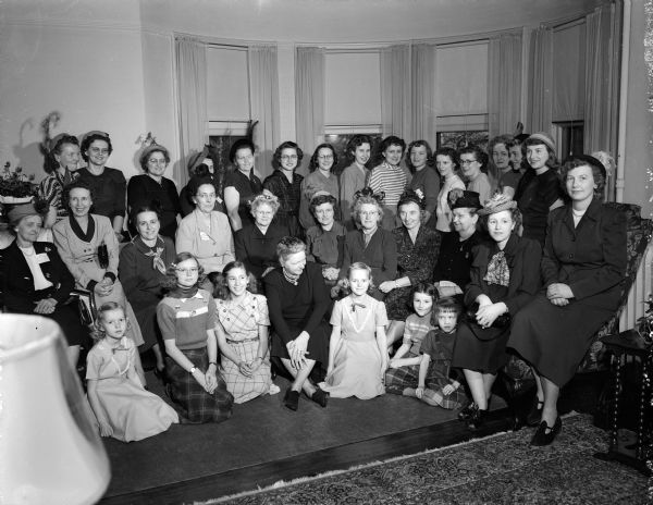 Group portrait of mothers and daughters with Mrs. E.B. (Rosa) Fred, wife of the university president in the Fred house at 10 North Babcock Drive. Farm families from eleven counties were guests of the Madison Business Association for the first annual Farm Family Day.