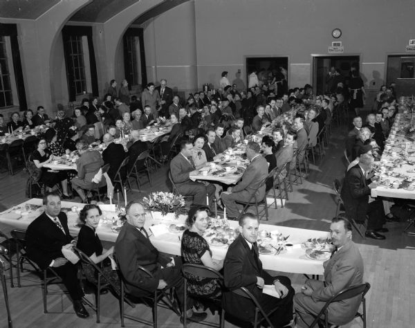 Elevated view of a portion of the crowd of 200 at the 95th birthday celebration dinner at the Turner hall. Those seated at the speakers' table are, left to right: Erwin Carter, Turner Society president; Mrs. Emma Carter; County Judge George Kroncke, Jr., master of ceremonies; Mrs. Jane Kroncke; Professor Lowell R. Laudon, University of Wisconsin geology department, principal speaker; and Henry Huebel, a Turner Society trustee and past president.
