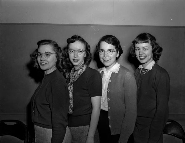 Group portrait of four Madison high school students, winners of the Daughters of the American Revolution (DAR) Good Citizenship Award. Pictured from left to right are Mary Bond, Cental High; Beth Mitchell, East High; Betty Casida, West High, and Helen Hosler, Wisconsin High.