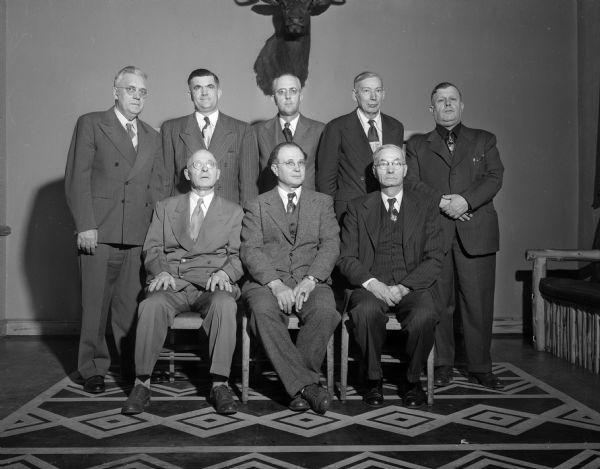 Group portrait of officers and directors of the Central Wisconsin Food Stores Cooperative that were reelected at the organization's twentieth anniversary meeting at the Park Hotel. Seated, left to right, are William Sweet, treasurer; Walter L. Plaenert, president; and O.T. Ullsvik, secretary, all of Madison. Standing, left to right, are L.L. Helland, Juda, director; Herman Schwarez, Madison, vice-president; A.E. Mack, Madison, director; Peter J. Zander, Cross Plains, director; and William J. Mason, Madison, manager.