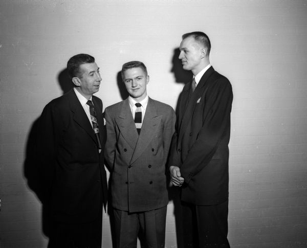 University of Wisconsin's basketball coach Harold E. "Bud" Foster (left) is shown with two of his 1949-1950 basketball stars at the team banquet. In the center is guard Bobby Mader, team captain and on the right is center Don Rehfeldt, the team's most valuable player.