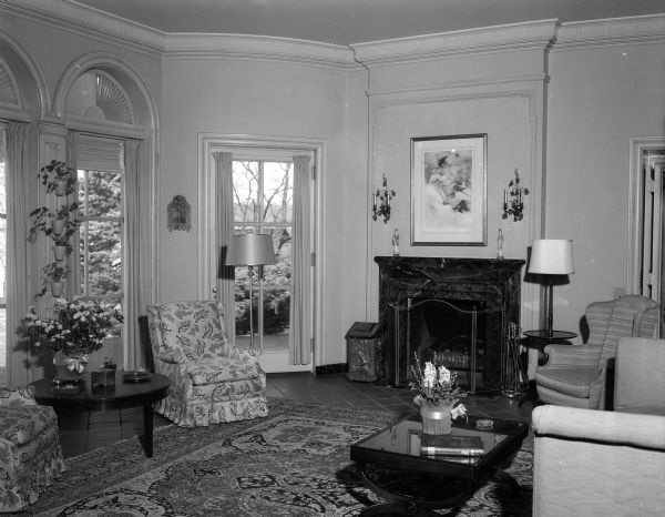 Living room in the Wisconsin Governor's residence at 101 Cambridge Road. The windowed terrace room with its tile floor and Oriental rug serves as the living room of the governor's family. The room takes its color scheme from shades in the fabric covering the easy chairs at left.