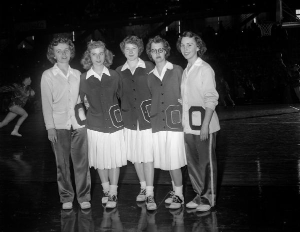 Onalaska cheerleaders stand along the sidelines in the University of Wisconsin Field House during a state high school basketball tournament. From left are: Pat Gile, Jeannine Schmidt, Theresa Jolivette, Janice Cox and Joyce Thaldorf.