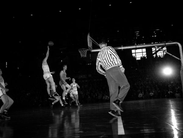 View of a game in play on Thursday during the boy's high school basketball tournament. Some images and players can be identified by reference to other published photos from games of this tournament.