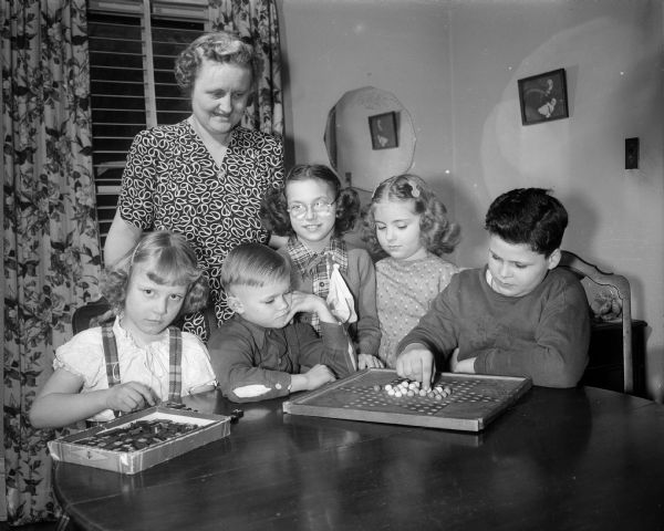 Under the eye of Esther Ruf and her daughter Karen, second from right, four handicapped children in foster care enjoy some games.