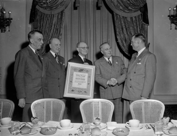 Walter S. Alcumbrac, Madison superintendent of the Madison division of the Chicago and North Western Railway Company, (right) receives a plaque for the best safety record of 1949 of all the divisions. Presenting the plaque are Chicago officials from the company (left to right): L.R. Lamport, engineer of maintenance; E.J. Crawford, superintendent of motive power; W.H. Roberts, safety superintendent; and C.H. Longman, vice-president in charge of operations.