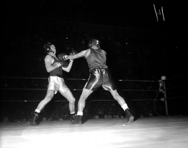 Les Paul of the University of Wisconsin, left, is jolted by a punch delivered by Dan Marquez of DePaul during a 135-pound boxing match.