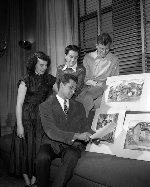 Three junior high school students, recipients of a 1949 summer scholarship, pose with their teacher near an exhibit of the students' watercolor sketches. Students, left to right:  Mary Markley, 246 Division Street, East Junior High; Eugene Nelson, 302 Huntington Court, Central Junior High; and Paul Hochstetter, 1105 West Johnson Street, West Junior High. Teacher: Frederick L. Carpenter, member of the Madison Art Association.