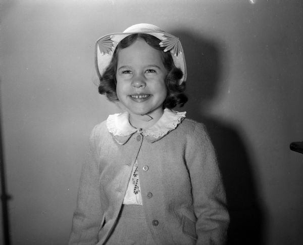 Virginia Ann Fenske is dressed in her yellow Easter ensemble with a frilly white blouse and a white straw hat with yellow cloche trim. She is the daughter of Mr. Charles H and Mrs. Viola O. Fenske of 4202 Bagley Parkway.