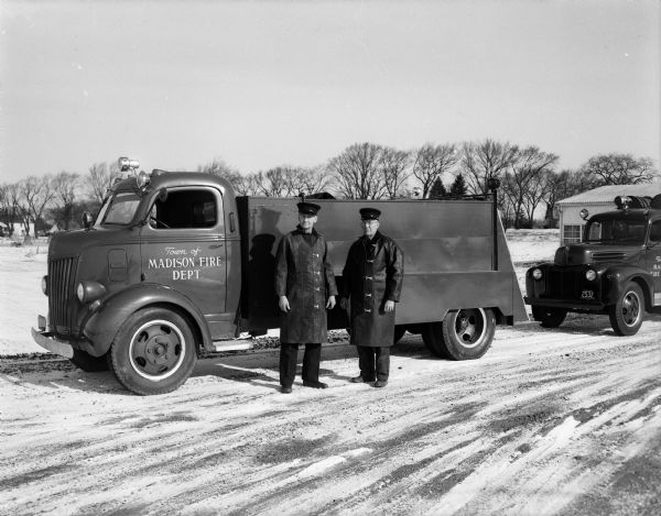 A reserve water tank truck with a 1,100 gallon capacity has been added to the town of Madison fire department to insure adequate water supply in fighting fires. Members of the department, Henry Johnson (right) and Grant Prideaux, are shown with the new apparatus which was assembled recently by the town mechanics. 
Attached to the rear of the truck is a portable pump which can be used to draw water from creeks, wells, or cisterns to fight fires.