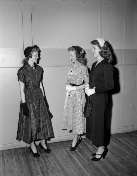 Three Madison high school girls modeling their Easter outfits featuring hats, dresses, gloves and high heeled shoes. Left to right: Lois Ann Hammer, West High; Lauretta Sullivan, Edgewood High; and Silvia Moen, East High.