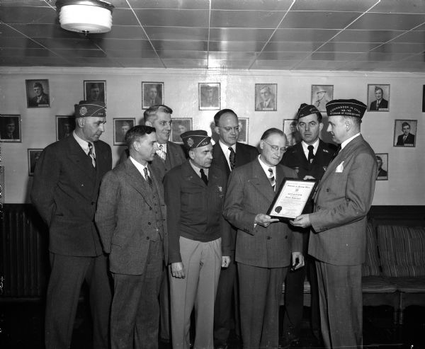 Joseph Rothschild, Madison civic and business leader, receives special recognition for his service to veterans and the community by the Madison Veterans of Foreign Wars post. Presenting the certificate is Lyall T. Beggs, past national commander. Looking on, left to right, are: Justice Timothy Brown of the state supreme court; Judge Douglas Nelson of the small claims court; C.L. Skinner, post commander; and C.A. Lewis, VFW district commander.