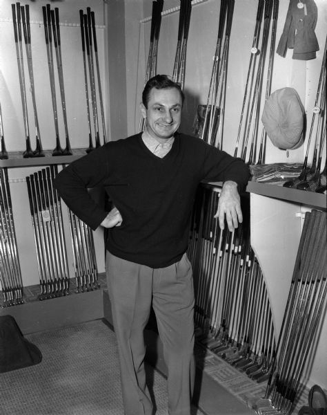 Tony Mierswa, the Maple Bluff Country Club professional, standing in the clubhouse near rows of golf clubs stored against the walls.