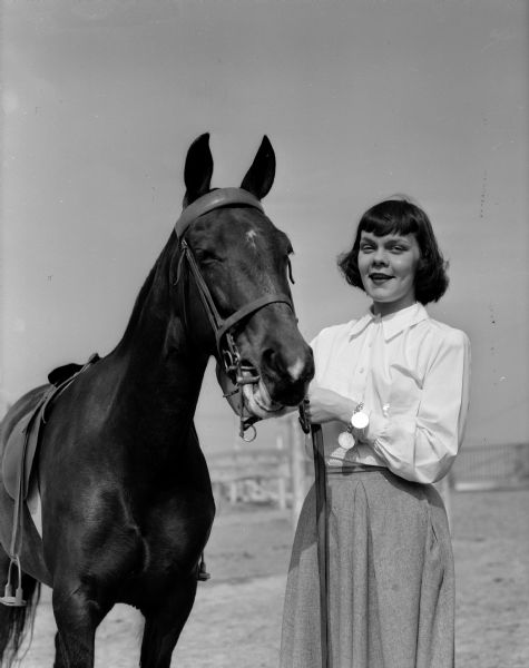 Jeanne Olson of 13 South Franklin Street, chairman of the grounds committee for the Hoofers' horse show, stands with her horse, "Her Highness".