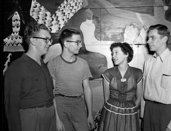 Four Madison high school musicians, participants in the annual music festival at the University of Wisconsin stock pavillion, posing for a group portrait. From left are: Jim Graham, Bob Schwartz, both from Central's band and orchestra; Zoya Zingale, from East's a cappella choir; and Don Liebenberg, of West's band and orchestra.