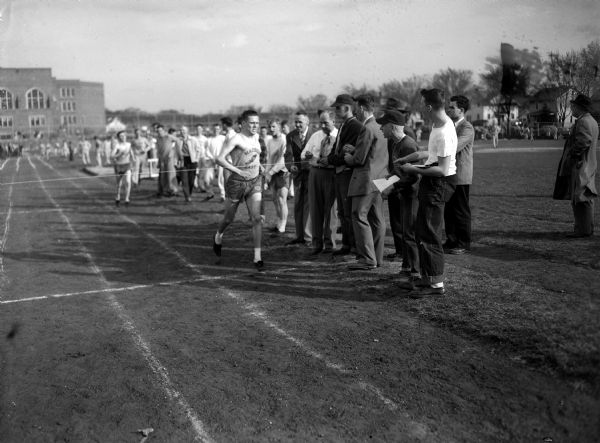Don Benn of East High School is pictured as he crosses the finish line in a tight race with Jim Ward of West High School in the annual track meet between East and West High schools.
