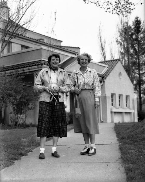 Marie Adele Fish, left, chairman of the women's organization at Maple Bluff Country Club, is joined by Dorothy Guild outside of a building (possibly the clubhouse) on Ladies' Day.