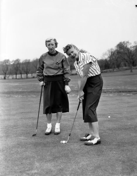 Women golfers at Maple Bluff Country Club. Virginia Sprague (right), chairman of the women's Maple Bluff rules committee, and Esther Hermsen prepare to putt.