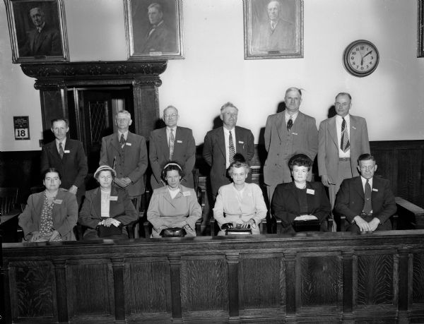 Group portrait of the George "Butch" King murder trial jury.  King, accused of the murder of Sadie Jackson, was declared not guilty by reason of insanity after a 21 day trial.  Left to right, front row: Mrs. Kenneth (Eugenie) Hoover, 64 Lansing Street; Mrs. Percy Olson, Dunkirk; Mrs. Lloyd Kelch, Paoli; Mrs. Fern Fowler, 3315 Blackhawk Drive; Mrs. Irving (Violet) Johnson 2561 Upham Street; and Carl Schwebs, Windsor. Back row: Hubert Kelter, Black Earth; Paul Jensen, Morrisonville; Sidney F. Pollard, 508 Ingersoll, Street; Oscar Hippe, Albion; John Spahn, Sun Prairie; and Einer Johnson, Brooklyn.
