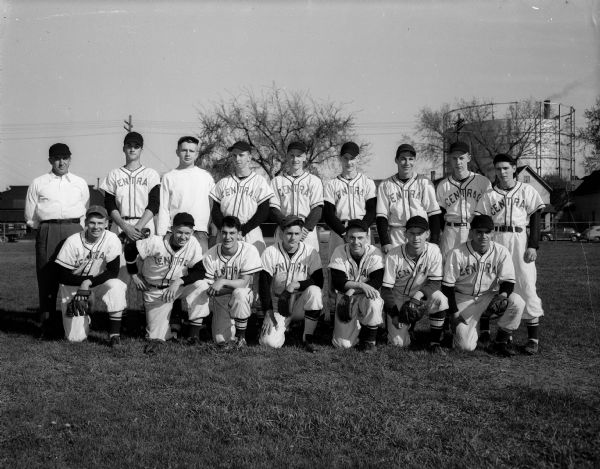 Group portrait of the uniformed Central High School baseball team with their coach, Harold "Gus" Pollock. A water tower is in the background on the right.