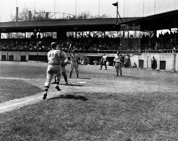 Paul Furseth, slugging outfielder from Edgerton, scores Wisconsin's first run of the game Saturday morning at Breese Stevens Field. Paul also scored the final run that gave Wisconsin a 7-6 victory over Michigan, a sweep of the series and a tie for first place in the Big 10 baseball race.