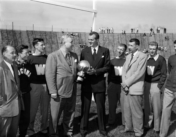 University of Wisconsin Don Rehfeldt receives MVP Award. Rehfeldt was named the Western Conference's most valuable basketball player.  Pictured from left are: Harry Struhldreher, Athletic Director; Don Gehrmann, Paul Furseth, Wilfred Smith, Don Rehfeldt, Robert "Red" Wilson, Harold E. "Bud" Foster, basketball coach; and Bruce Fossum. Wilfred Smith of the Chicago Tribune presented the award.  Gehrmann, Wilson and Fossum are representatives of the Student "W" Club.