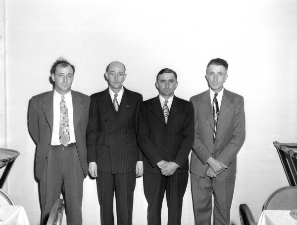 Four men pose for a photograph at the Farm Service Motor Carriers Dinner Meeting.  Four negatives of 13 people, possibly Wisconsin State Journal Farm Service Motor Carriers?