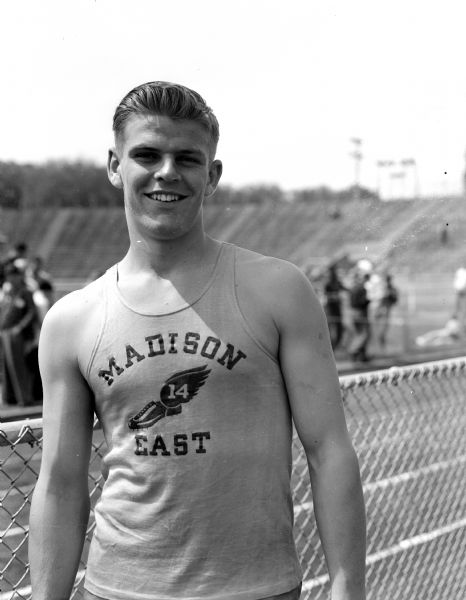 Portrait of Leo Schlilcht of East High School on the track field. Schlilcht was the winner of the Class A discus throw in the WIAA State Prep track meet.