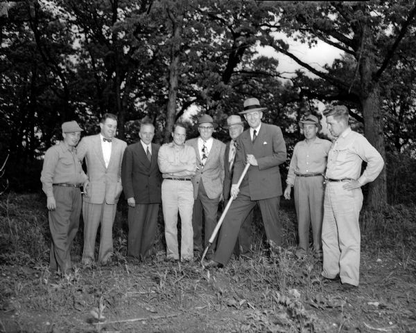 City Manager Leonard G. Howell turns the first shovelful of dirt for the first of eleven houses to be built by Madison builders under the Good American Homes program. Looking on are, from left to right, C.J. Goucher, John McKenna, Malcohm Andrews, Tom McGovern, E.B. Sokoloski, L.F. Thomas, Charles Fay, and E.O. Dahl. The houses will be part of the Parade of Homes on September 10, 1950.
