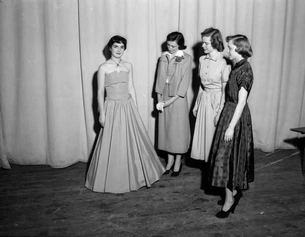 Four high school girls wear dresses for a style show.
