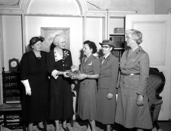A book on Girl Souting by a Wisconsin author is presented to Mary Rennebohm, wife of Governor Oscar Rennebohm, for her Wisconsin library. Pictured during the presentation are, left to right: Mrs. Howard Jackson, Chicago, chairman of the Great Lakes Region Girl Scouts; Mrs. Rennnebohm; Mrs. J.H. (Marian) Cottrell, Jr.; Mrs. Cass M. Williams, executive director of the Dane County Area Girl Scouts; and Mrs. J.O. Wilson, president of the Dane county area council.