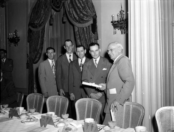 Voyta Wrabetz (right), chairman of the Wisconsin Industrial Commission, awarded diplomas of apprenticeship completion to 120 apprentices of the Madison building trades at their testimonial dinner in the Hotel Loraine. Pictured left to right are: Earl Frey, sheet metal; Ralph Schweppe, carpenter; Pete Gauer, steamfitter, and Manford Kvamme, electrician.