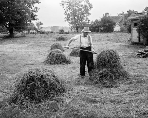 World War II war relief work. Man pitching hay.