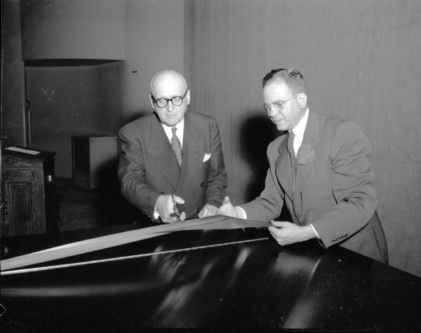 University of Wisconsin President E.B. Fred (left) accepts a $6,000 Steinway concert grand piano from the Class of 1925 on Alumni Day. John L. Bergstresser (right), University of Chicago, represents the Class of 1925.  A short dedicatory concert was presented by Gunner Johansen, artist-in-residence at the school of music, who selected the piano.