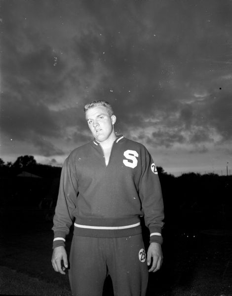 Portrait of Stanford University's Don Chandler, who won the shot put competition at the Big Ten-Pacific Coast intercollegiate track meet by setting a meet record of 56 feet and 1 3/4 inches. The meet was held at Camp Randall stadium.