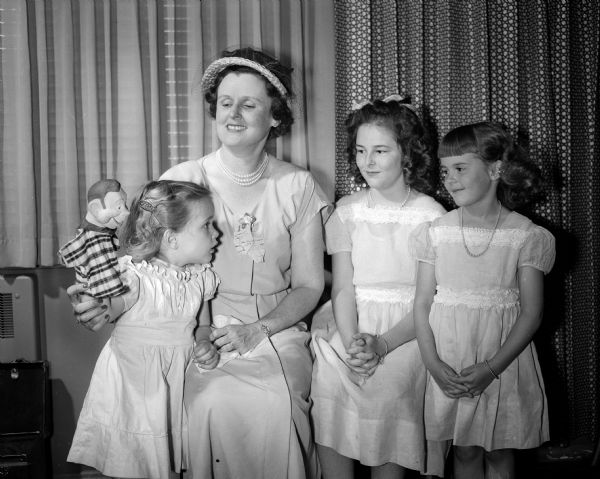 Cameron Thompson, age three, showing her puppet to Mrs. William S. Hooper of Minneapolis and to Gail and Jacqueline Harmon during the sorority marionette show at the Edgewater Hotel.