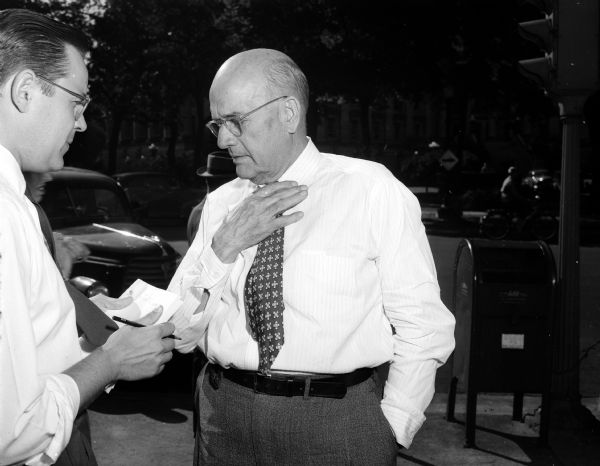 Journalist John Prindle, left,  conducts an on-the-street interview of T.B. Peterman, realtor, about his opinions on the Korean War.
