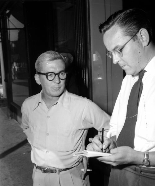 Journalist John Prindle, right, conducting an on-the-street interview with W.H. Kelly, a sporting goods dealer and Navy veteran, about his opinions on the Korean War.