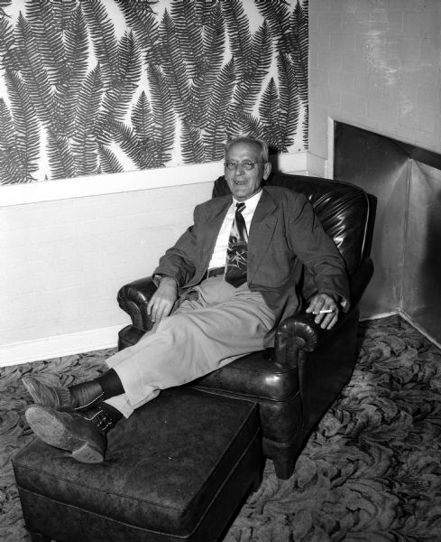 Henry M. Zweifel, former district manager of the Kroger Company, tries out a chair and ottoman presented to him by Kroger employees at his retirement dinner.