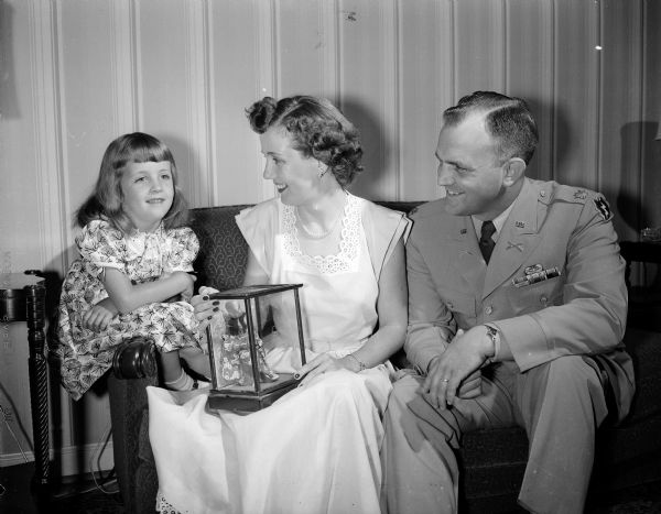 Portrait of Martha Lynne Dean, age 5 1/2, with one of her Japanese dolls, and her parents Mrs. and Major William A. Dean, who are returned from Kyoto, Japan.