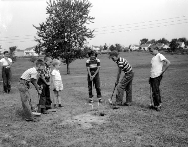 Girls and boys participate in a lively croquet game at the Westmorland park playground.  They are, from left to right: Jay Voss, Jimmy Leahy, Jimmie Montgomery, Bonnie Henderson, Jim Olson, and Butch Meyers. The game and other playground activities are sponsored by the city's board of education recreation division.
