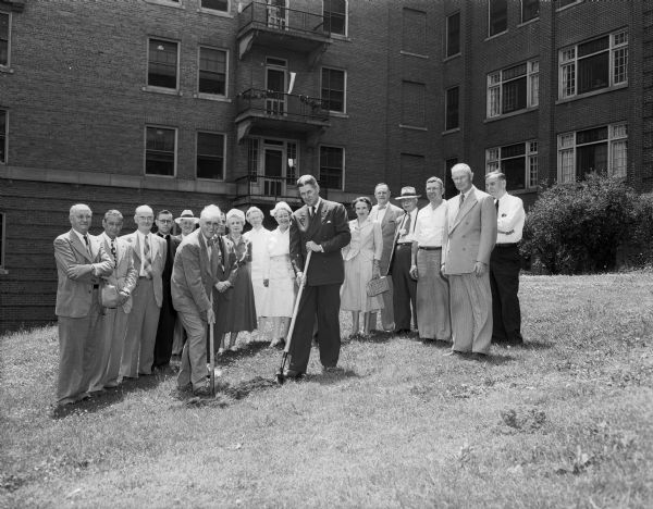 Edward J. B. Schubring (left), president of Madison General hospital association, and City Manager Leonard G. Howell wield the shovels at the groundbreaking ceremony for a new addition to Madison General Hospital. Looking on are city council members, hospital officials and board members, and the architect Ellis J. Potter.