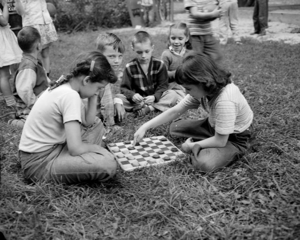 Sherry Klein (right) playing a game of checkers with Janice Wirioff at the Milton-Charter park playground as Edward Lambert, Kenneth and Shirley Bloom are looking on.